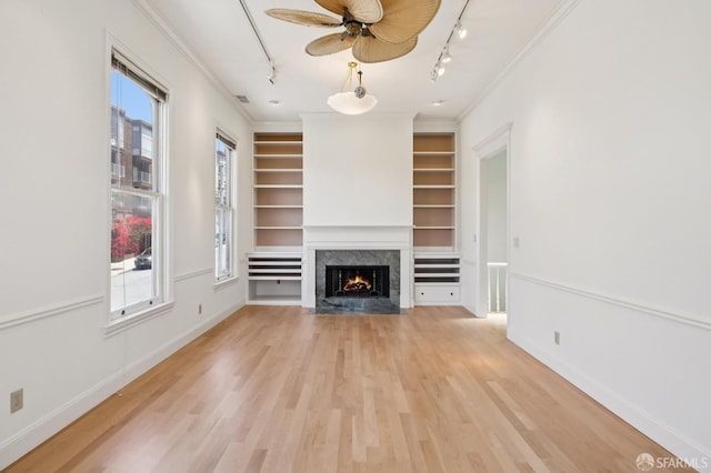 1695 Sutter St, San Francisco, CA 94109 - unfurnished living room featuring rail lighting, a premium fireplace, healthy amount of natural light, light wood-style flooring, and crown molding
