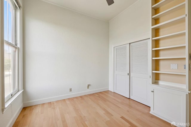 1695 Sutter St, San Francisco, CA 94109 - unfurnished bedroom with light wood-type flooring, multiple windows, a closet, a ceiling fan, and crown molding