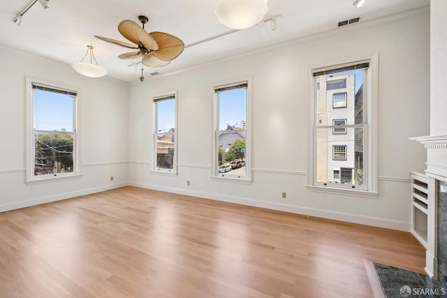 1695 Sutter St, San Francisco, CA 94109 - unfurnished room with crown molding, healthy amount of natural light, a fireplace, rail lighting, and light wood finished floors
