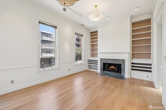 1695 Sutter St, San Francisco, CA 94109 - unfurnished living room with crown molding, built in features, light wood-style floors, a premium fireplace, and track lighting