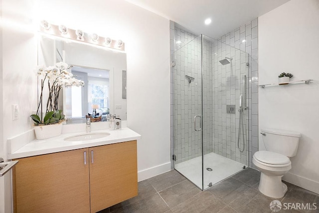 bathroom featuring toilet, vanity, baseboards, tile patterned floors, and a stall shower