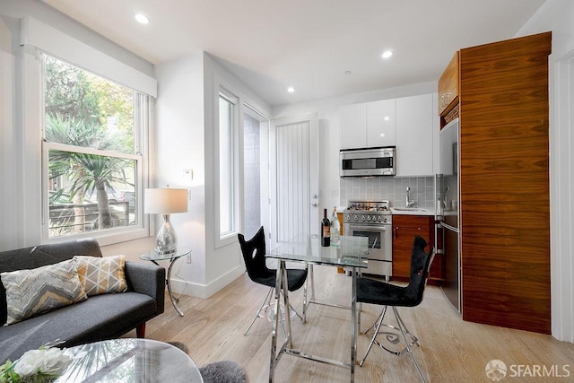 dining space featuring light wood-style floors, baseboards, and recessed lighting