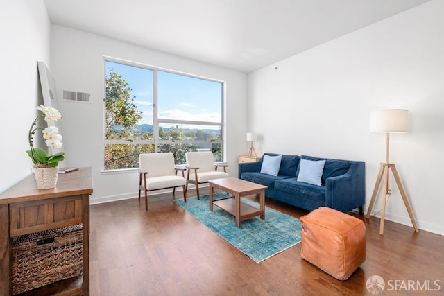 living room featuring plenty of natural light and dark hardwood / wood-style flooring