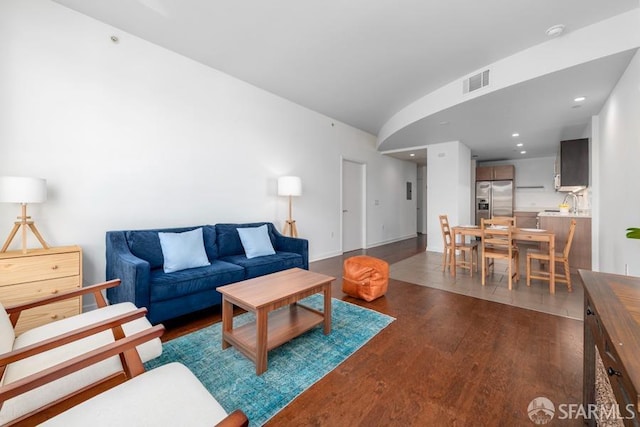 living room featuring lofted ceiling and dark hardwood / wood-style floors