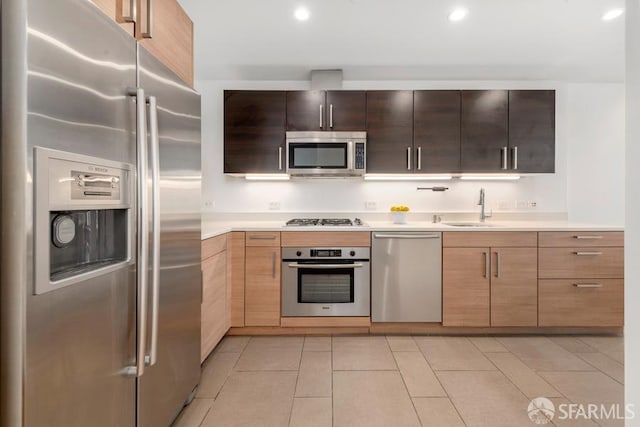 kitchen featuring light tile patterned floors, stainless steel appliances, and sink