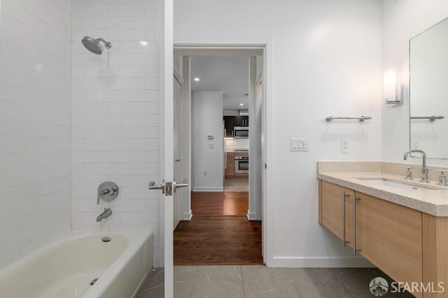 bathroom with vanity, tiled shower / bath combo, and wood-type flooring