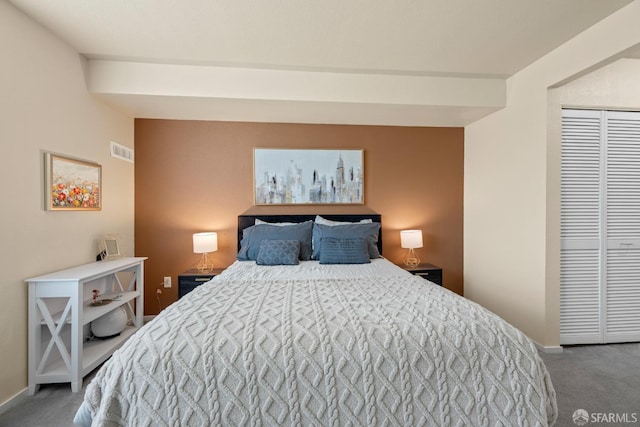 carpeted bedroom featuring a closet, visible vents, and baseboards