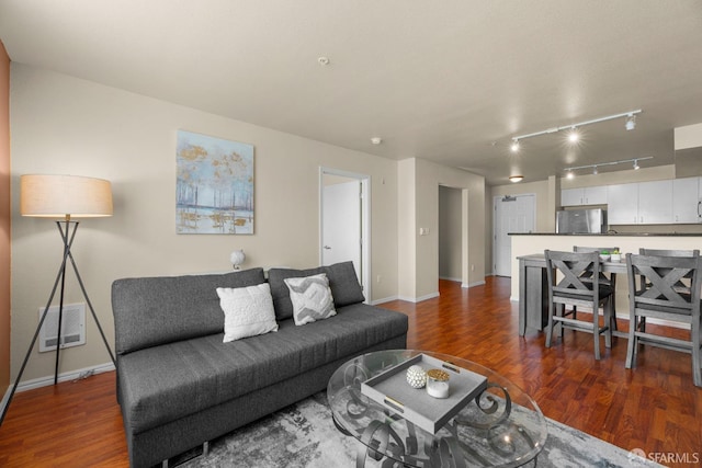 living area featuring wood finished floors, visible vents, and baseboards