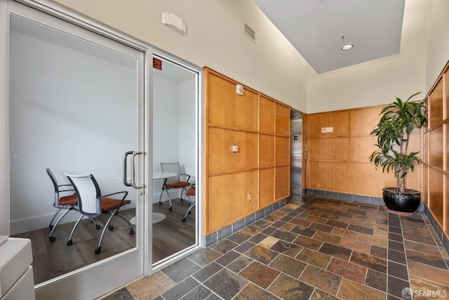 interior space featuring recessed lighting, visible vents, stone tile floors, and a towering ceiling