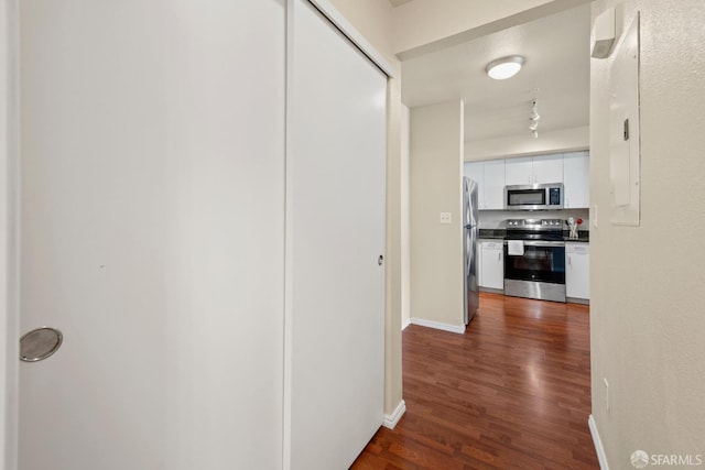 hallway with baseboards and dark wood-style flooring