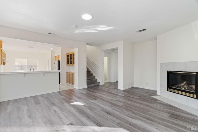 unfurnished living room with a fireplace and light hardwood / wood-style floors