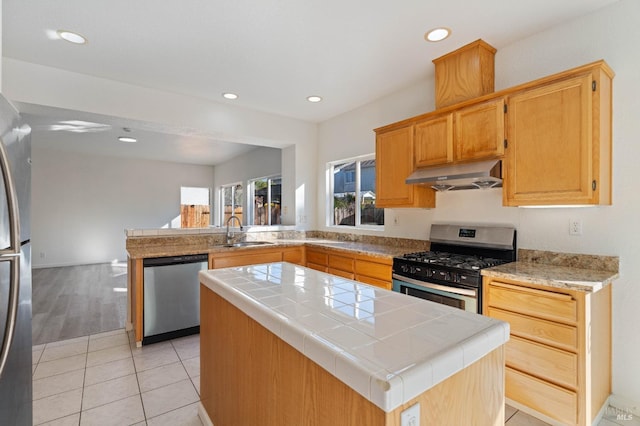 kitchen with light tile patterned flooring, sink, a center island, kitchen peninsula, and stainless steel appliances