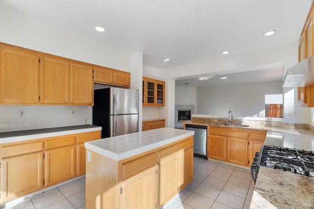 kitchen featuring sink, appliances with stainless steel finishes, a center island, light tile patterned flooring, and kitchen peninsula