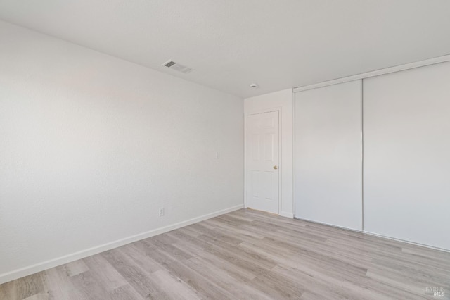 unfurnished bedroom featuring a closet and light hardwood / wood-style flooring