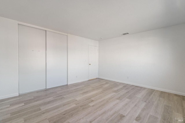 unfurnished bedroom with light hardwood / wood-style floors and a closet