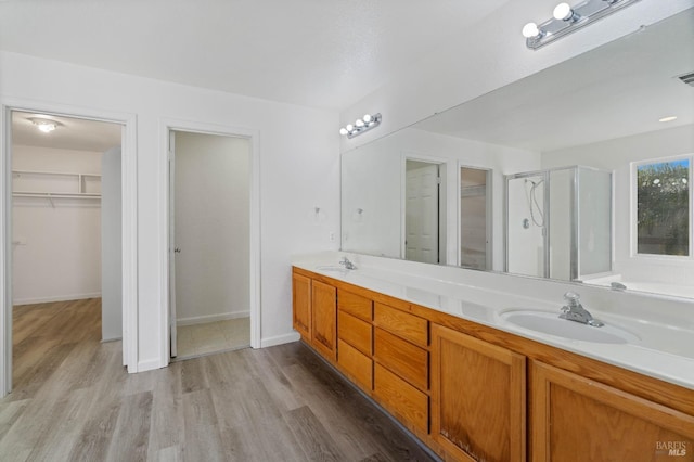 bathroom with hardwood / wood-style flooring, vanity, and a shower with shower door