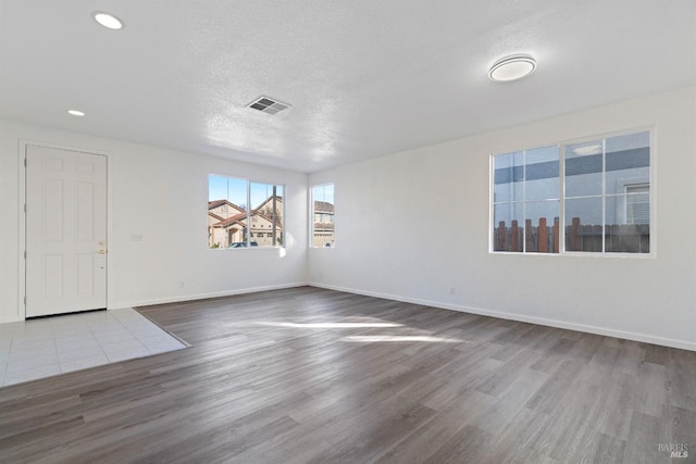 spare room with wood-type flooring and a textured ceiling