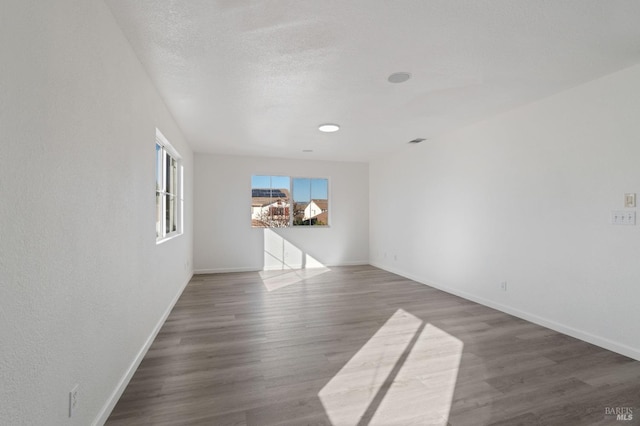 unfurnished room featuring dark hardwood / wood-style floors and a textured ceiling