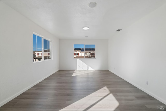 unfurnished room featuring dark hardwood / wood-style floors and a textured ceiling