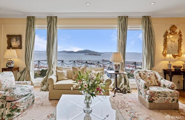 living room featuring ornamental molding, wood-type flooring, and a water view