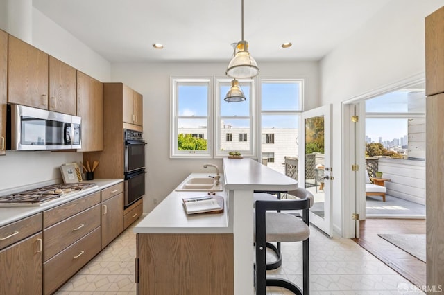 3364 21st St, San Francisco, CA 94110 - kitchen with stainless steel microwave, gas stovetop, a kitchen bar, light countertops, and pendant lighting