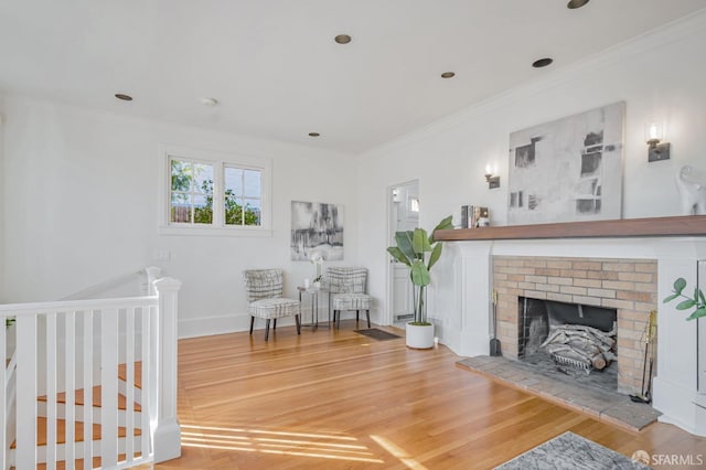 interior space featuring ornamental molding, a fireplace, baseboards, and wood finished floors