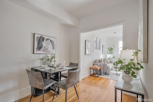 dining area with baseboards and wood finished floors