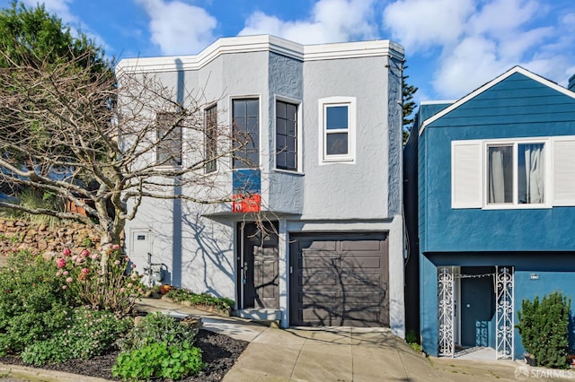 view of front of property featuring stucco siding, driveway, and an attached garage