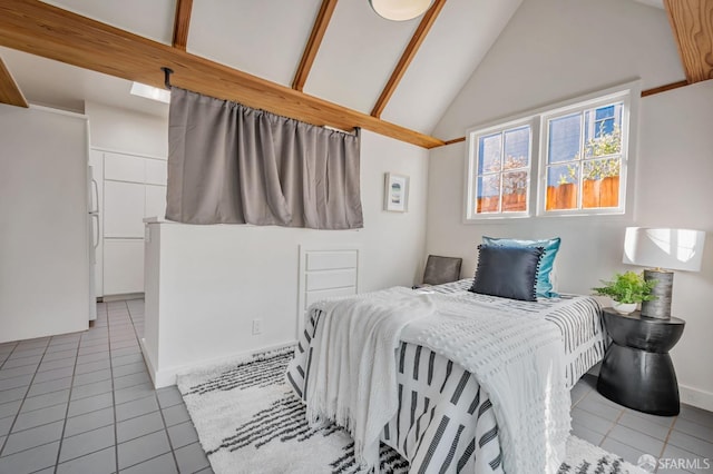 tiled bedroom featuring freestanding refrigerator, baseboards, and vaulted ceiling