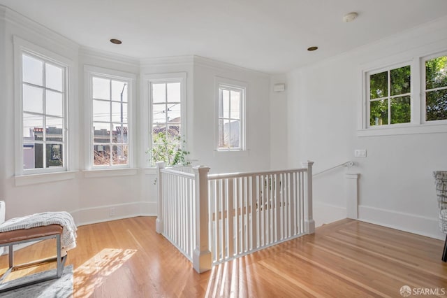 corridor featuring an upstairs landing, baseboards, and wood finished floors