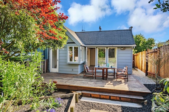 back of property featuring fence, roof with shingles, and a wooden deck