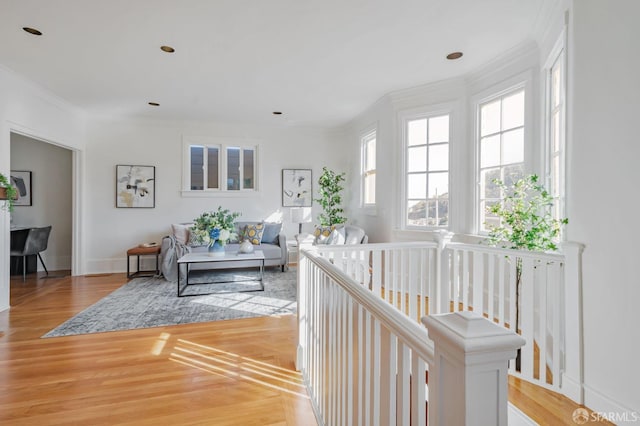 living room with baseboards, light wood-style floors, and crown molding