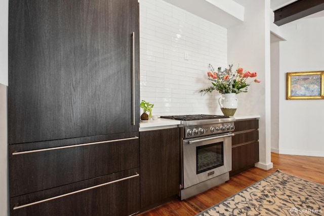 kitchen featuring backsplash, fridge, dark wood-type flooring, dark brown cabinets, and high end stainless steel range