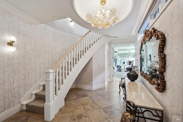 staircase with crown molding and an inviting chandelier