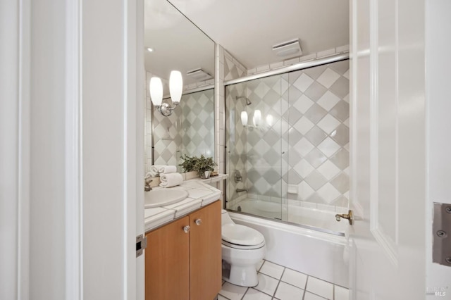 full bathroom featuring tile patterned flooring, vanity, toilet, and bath / shower combo with glass door