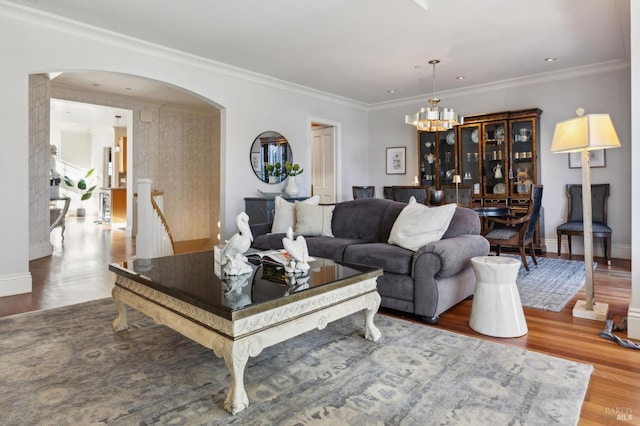 living room featuring hardwood / wood-style floors, a notable chandelier, and crown molding