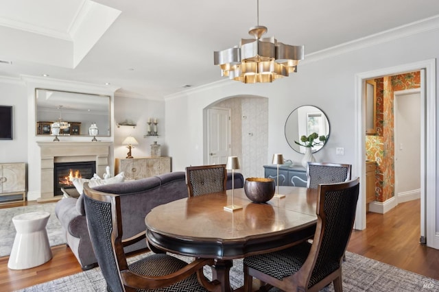 dining room featuring a notable chandelier, wood-type flooring, and ornamental molding