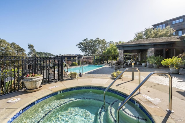 view of swimming pool featuring a patio area and a community hot tub