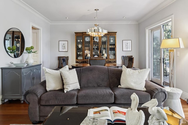 living room featuring wood-type flooring, crown molding, and an inviting chandelier