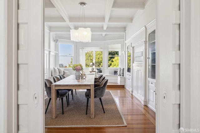 dining area with beam ceiling, coffered ceiling, wood-type flooring, and a chandelier