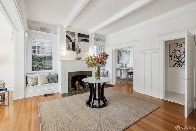 sitting room with beam ceiling, wood-type flooring, and a fireplace