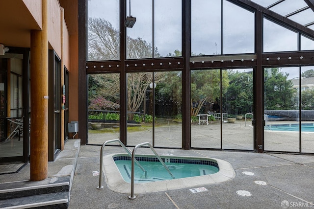 view of swimming pool featuring an indoor hot tub and a patio area