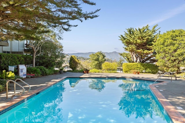 view of pool with a patio area and a mountain view