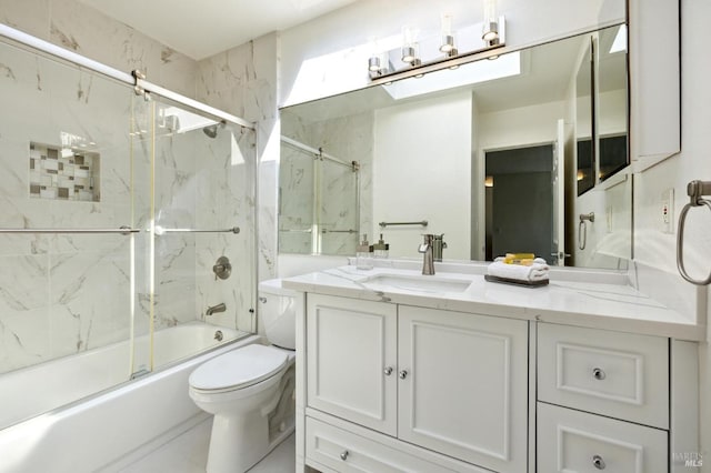 full bathroom with vanity, shower / bath combination with glass door, and toilet