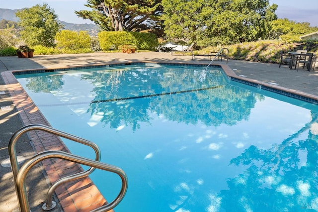 view of pool with a patio area and a mountain view