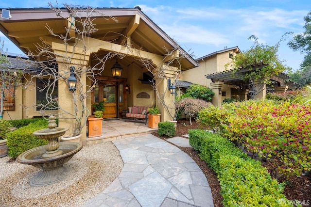 entrance to property with a patio area and stucco siding