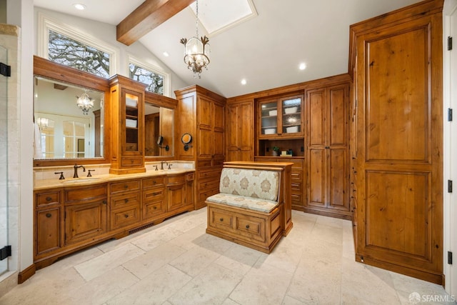 full bath with beam ceiling, a notable chandelier, and a sink