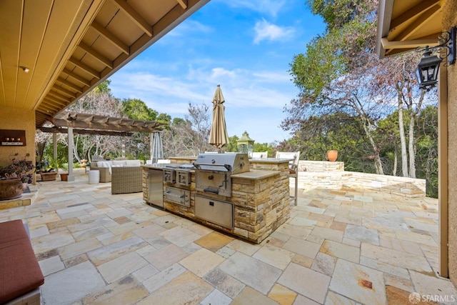 view of patio with a grill, a pergola, an outdoor living space, and exterior kitchen