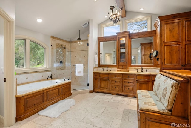 bathroom featuring vaulted ceiling, a stall shower, and a sink