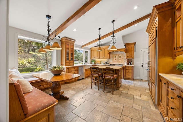 kitchen featuring glass insert cabinets, stone tile flooring, light countertops, and a kitchen island